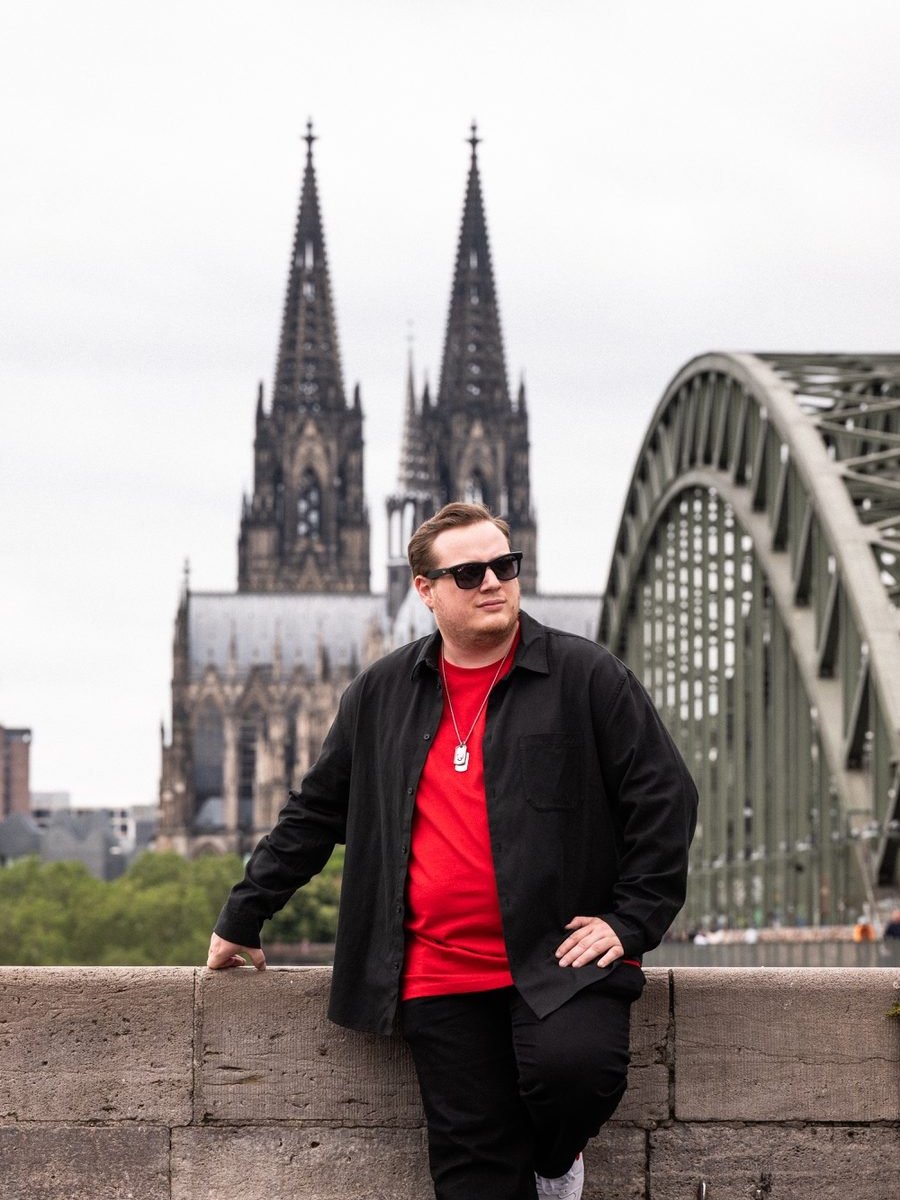 Nik Lewin vor Kölner Dom und Hohenzollernbrücke